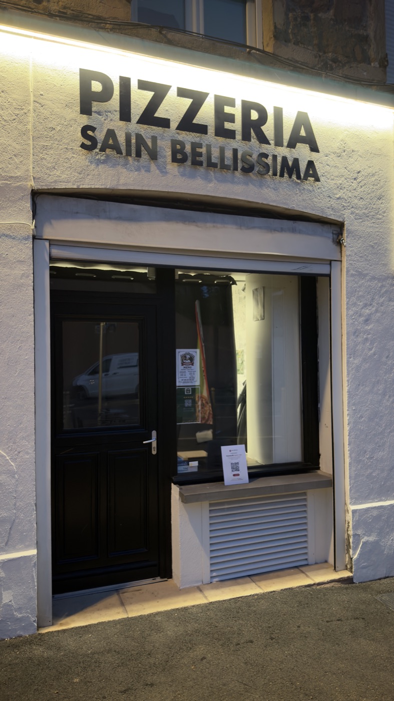 Devanture de la pizzeria Sain Bellissima à Sain-Bel, éclairée le soir